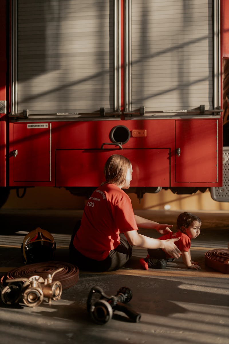 A firefighter mother and her small child bonding in a fire station.