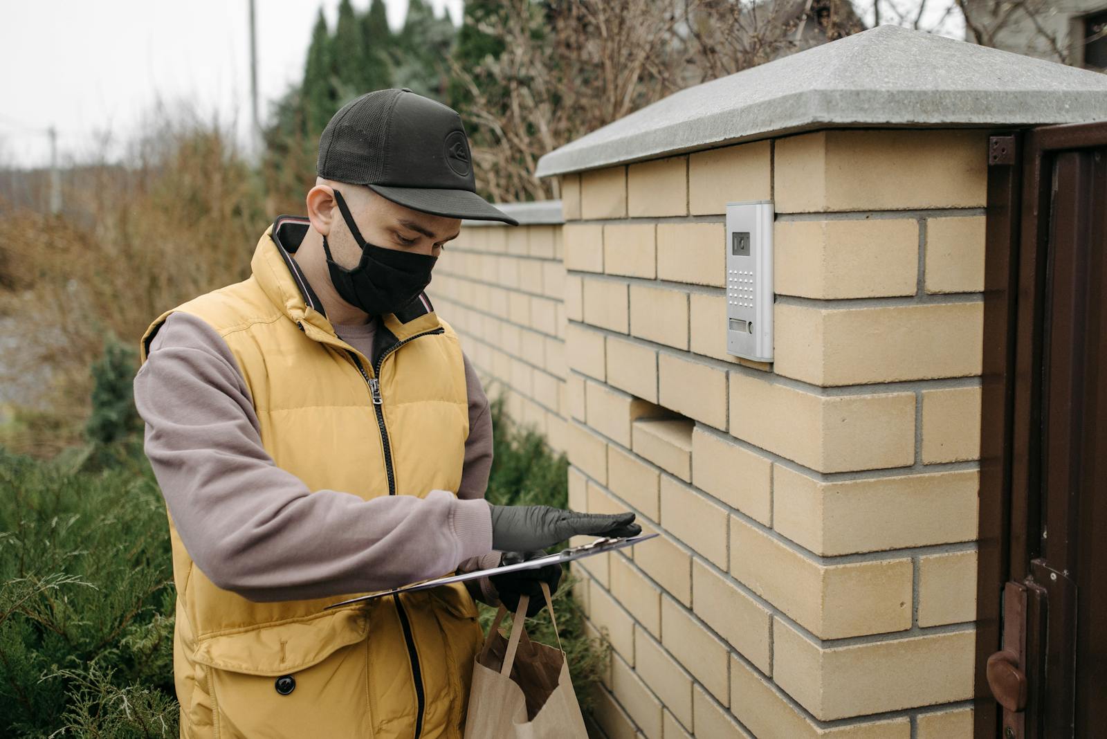 Courier wearing a mask and gloves delivering a package during COVID-19. Safety and efficiency.