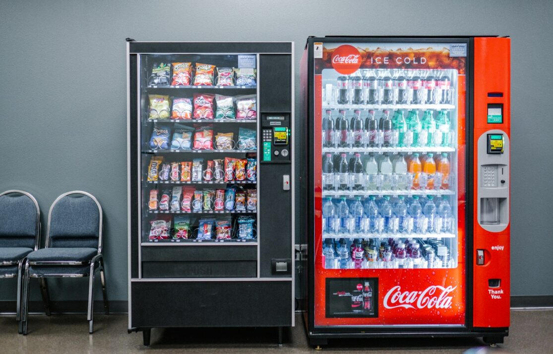coca cola and coca cola bottles in black vending machine